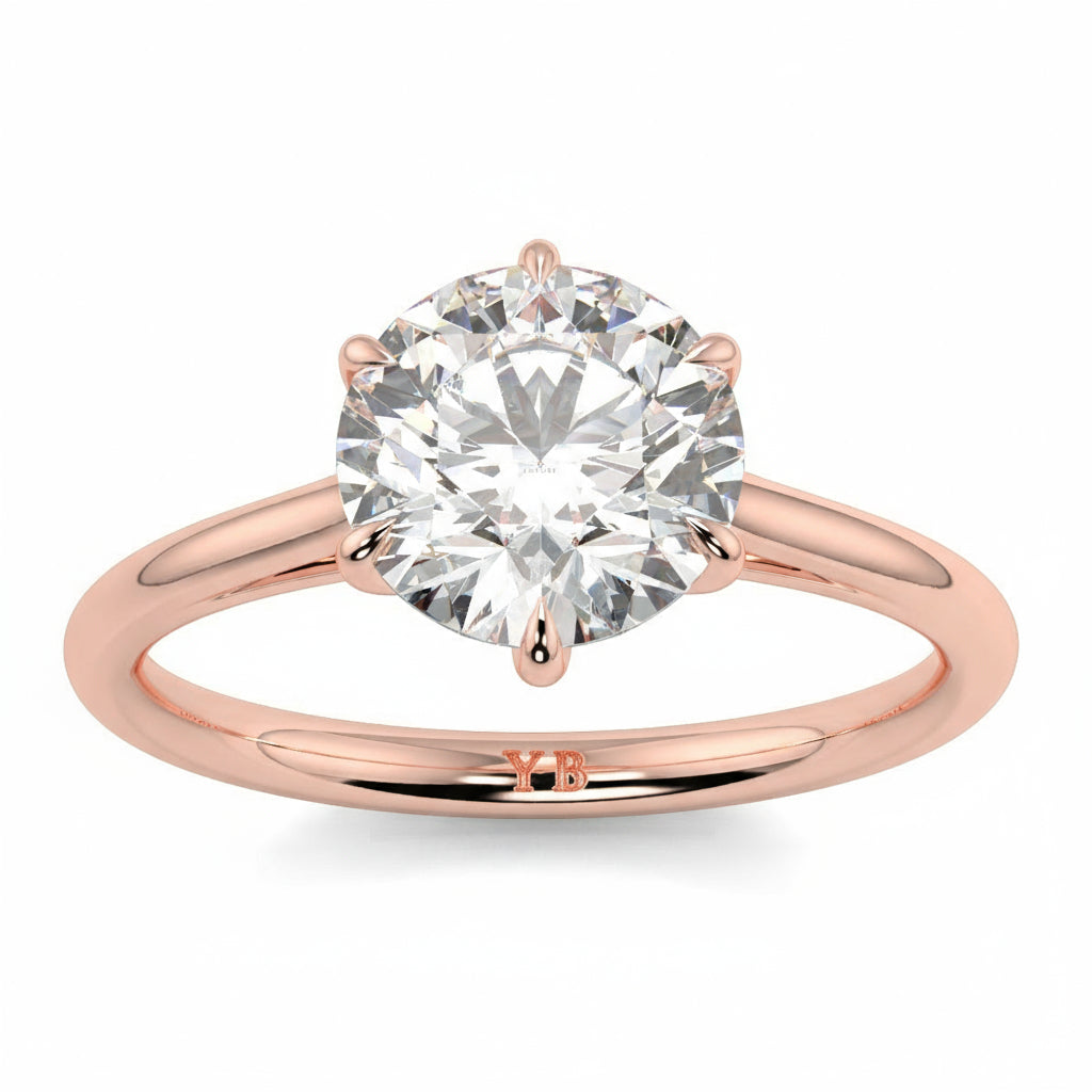 Rose gold ring with a large diamond and branding on a white background yb jewellers solitaire engagement ring with 6 claws set similar to tiffany style classic engagement ring round solitaire diamond ring yb jewellers trending jeweller and ring designs