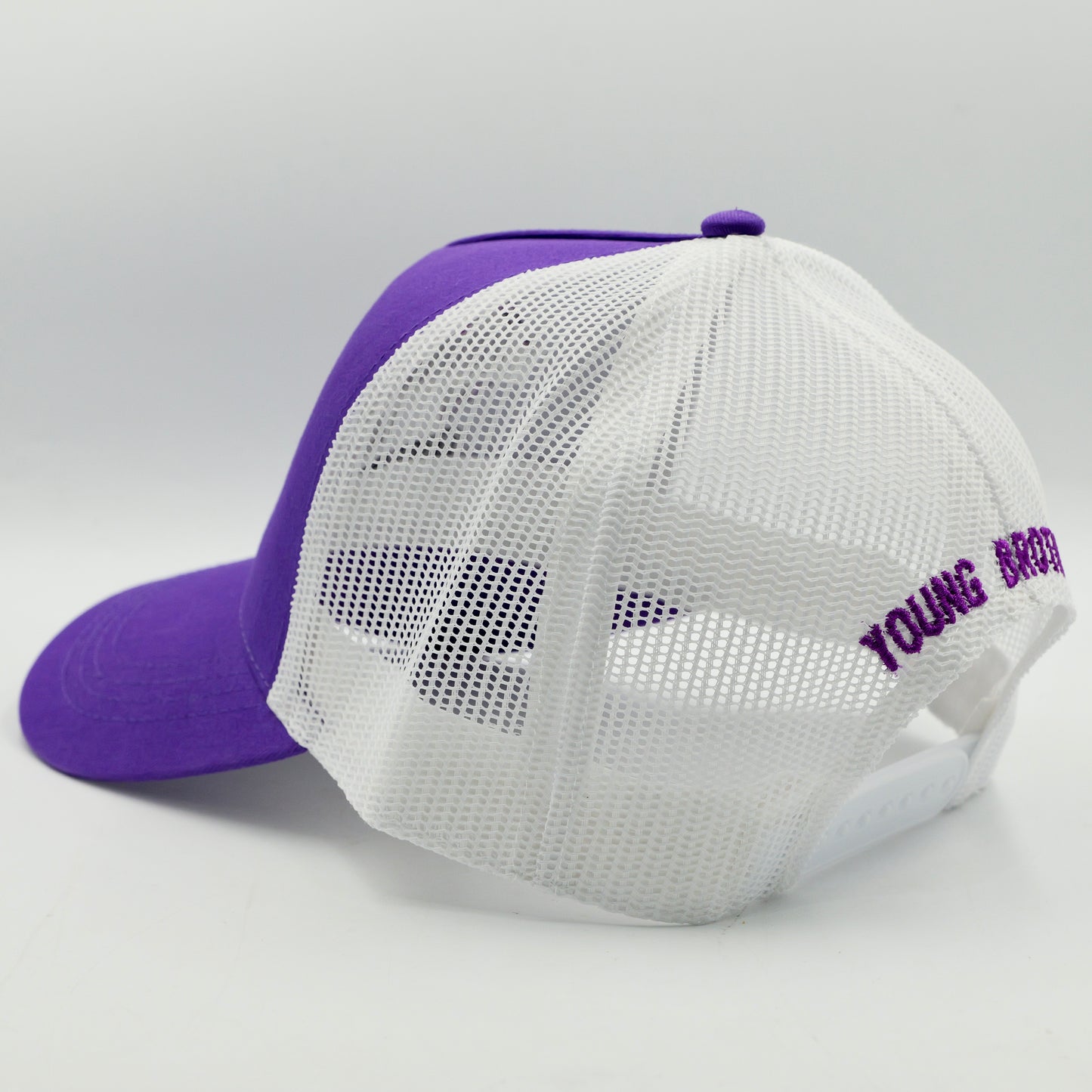 Purple and white cap with mesh back on a light gray background