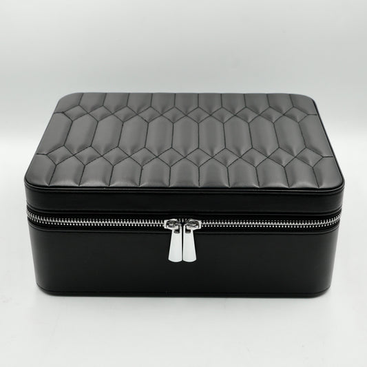Black quilted jewelry box with a silver zipper on a white background