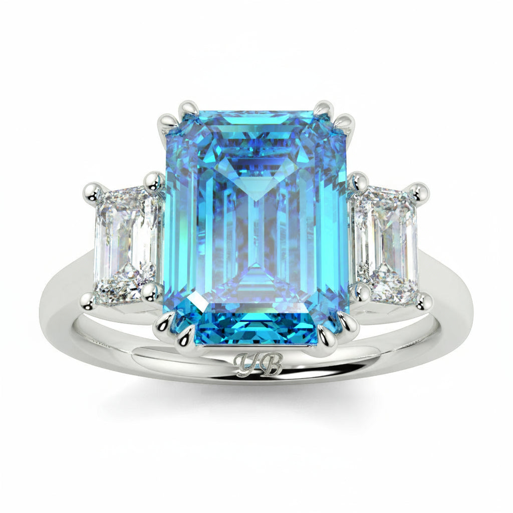 Ring with blue gemstone and diamonds on a white background yb jewellers trilogy emerald cut engagement ring lab grown diamonds coloured diamonds platinum ring