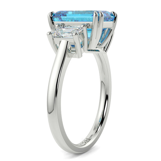Silver ring with a blue gemstone on a white background yb jewellers trilogy emerald cut engagement ring lab grown diamonds coloured diamonds platinum ring
