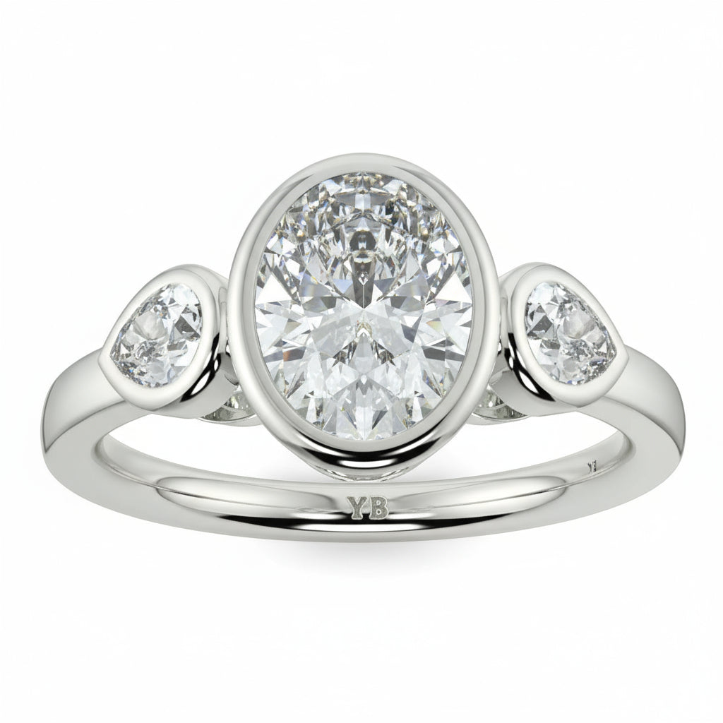 Silver ring with three diamonds on a white background oval and pear diamond trilogy ring yb jewellers best selling design and engagement rings 