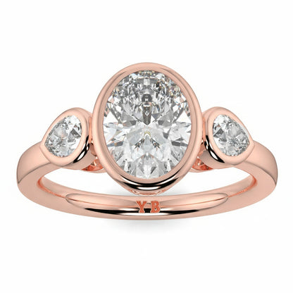 Rose gold ring with three diamonds on a white background, featuring the brand oval and pear diamond trilogy ring yb jewellers best selling design and engagement rings 