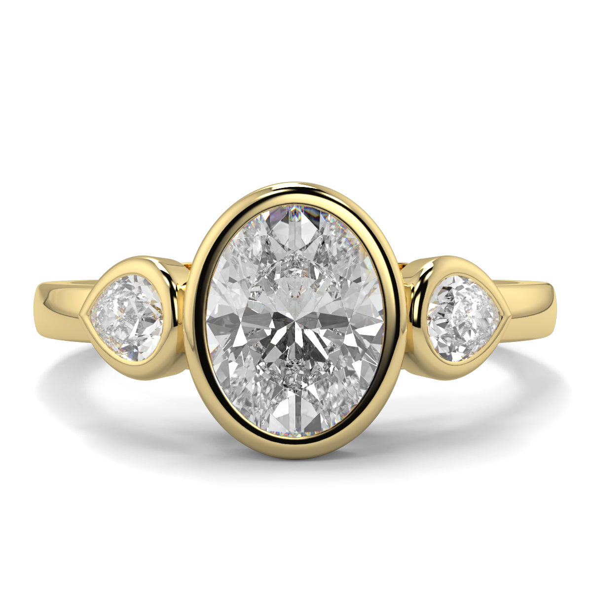 Gold ring with a central diamond flanked by two smaller diamonds on a white background oval and pear diamond trilogy ring yb jewellers best selling design and engagement rings 