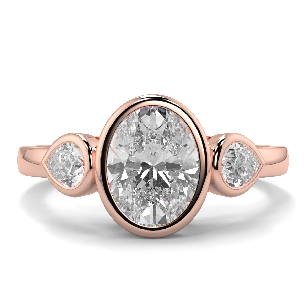 Rose gold ring with three diamonds on a white background oval and pear diamond trilogy ring yb jewellers best selling design and engagement rings 