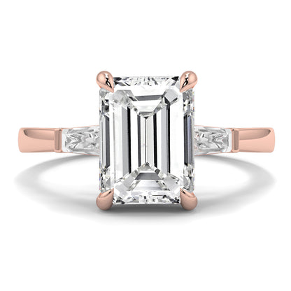 Rose gold ring with a large emerald-cut diamond on a white background yb_jewellers_3_stone_trilogy_engagement_ring_round_and_pear_shape_best_selling_design_trending_diamond_ring