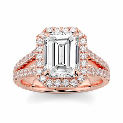 Rose gold ring with emerald-cut diamond and smaller diamonds on a white background Yb jewellers emerald split halo diamond engagement ring 