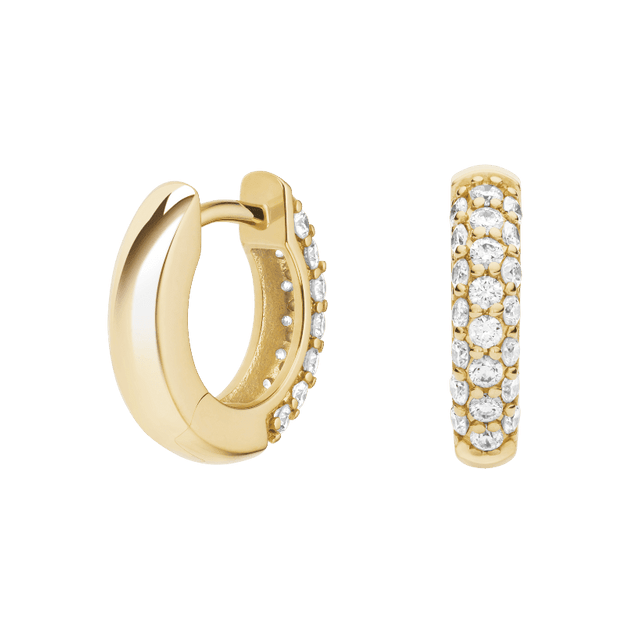 Gold hoop earrings with embedded stones on a green background pair of huggiee earrings in 18k white gold platinum with micro diamond setting by yb jewellers 