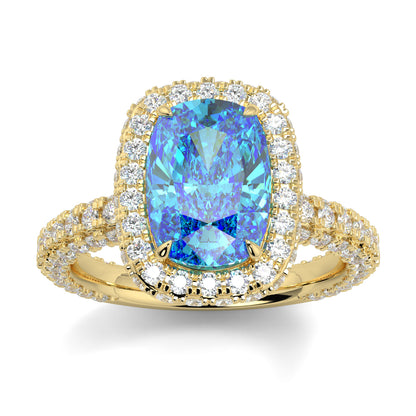 Gold ring with a blue gemstone and diamond accents on a white background yb jewellers cushion blue diamond engagement ring in a halo diamond ring lab grown with diamond encrusted hidden halo and band