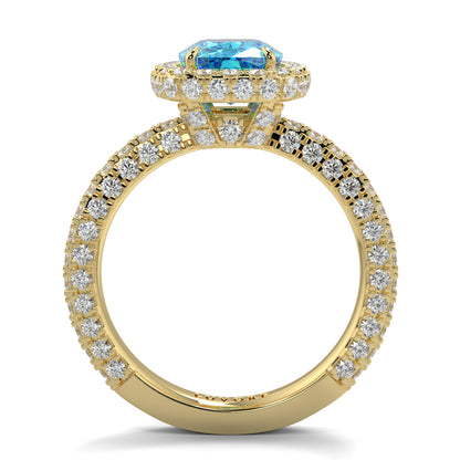 Gold ring with a blue gemstone and diamond accents on a white background yb jewellers cushion blue diamond engagement ring in a halo diamond ring lab grown with diamond encrusted hidden halo and band