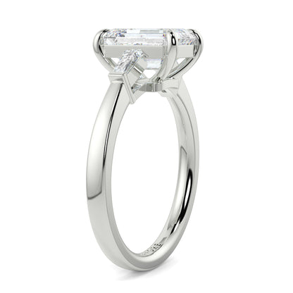 Diamond ring with a rectangular cut gemstone on a white background yb_jewellers_3_stone_trilogy_engagement_ring_round_and_pear_shape_best_selling_design_trending_diamond_ring
