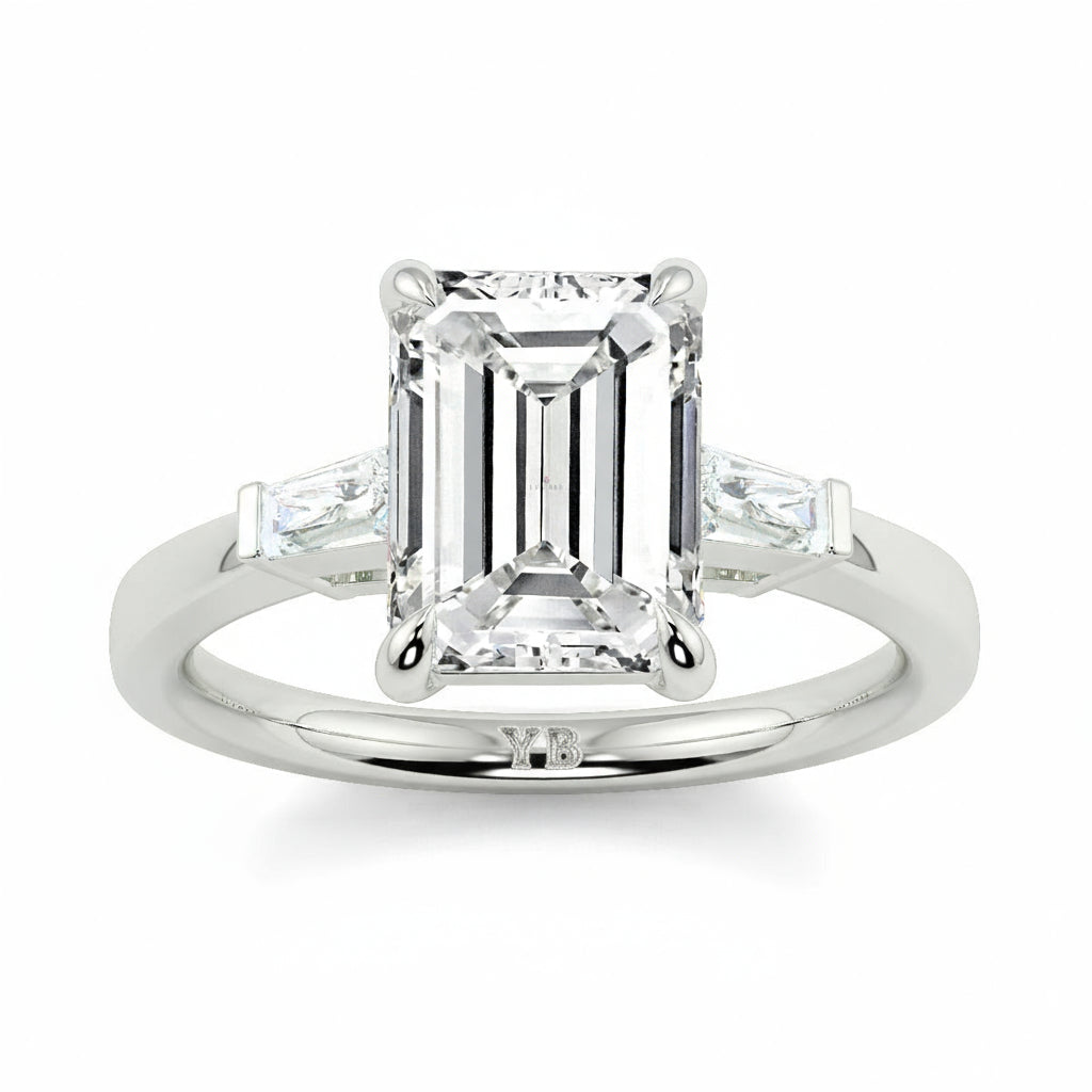 Diamond ring with emerald-cut center stone and baguette side stones on a white background yb_jewellers_3_stone_trilogy_engagement_ring_round_and_pear_shape_best_selling_design_trending_diamond_ring