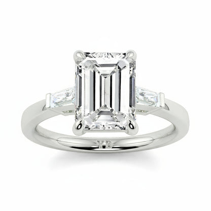 Diamond ring with emerald-cut center stone and baguette side stones on a white background yb_jewellers_3_stone_trilogy_engagement_ring_round_and_pear_shape_best_selling_design_trending_diamond_ring