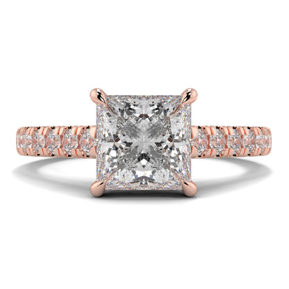 Rose gold ring with a large diamond and smaller diamonds on the band against a white background Yb jewellers engagement ring straight band