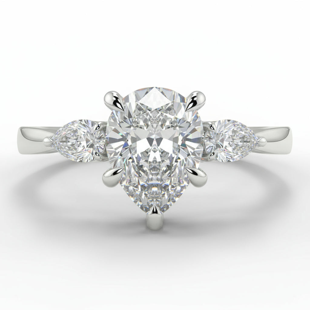 Diamond ring with a pear-shaped center stone on a white background _yb_jewellers_3_stone_trilogy_engagement_ring_round_and_pear_shape_best_selling_design_trending_diamond_ring