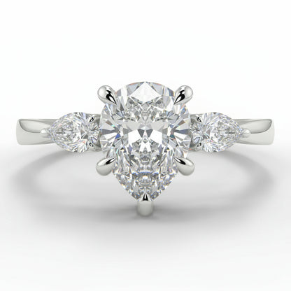 Diamond ring with a pear-shaped center stone on a white background _yb_jewellers_3_stone_trilogy_engagement_ring_round_and_pear_shape_best_selling_design_trending_diamond_ring