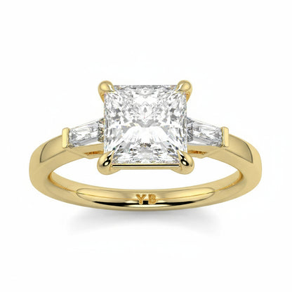 Gold ring with a diamond on a white background yb_jewellers_3_stone_trilogy_engagement_ring_round_and_pear_shape_best_selling_design_trending_diamond_ring