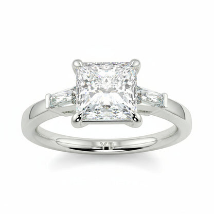 Diamond ring with a princess-cut center stone on a white background yb_jewellers_3_stone_trilogy_engagement_ring_round_and_pear_shape_best_selling_design_trending_diamond_ring