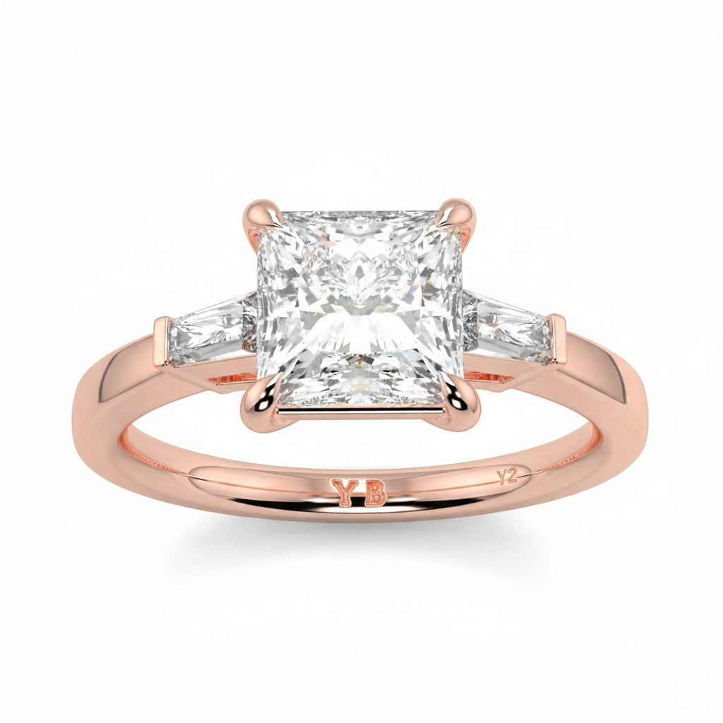 Rose gold ring with a diamond on a white background yb_jewellers_3_stone_trilogy_engagement_ring_round_and_pear_shape_best_selling_design_trending_diamond_ring