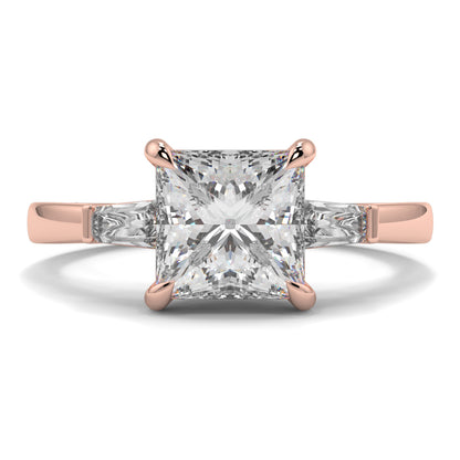 Rose gold ring with a large diamond on a white background yb_jewellers_3_stone_trilogy_engagement_ring_round_and_pear_shape_best_selling_design_trending_diamond_ring