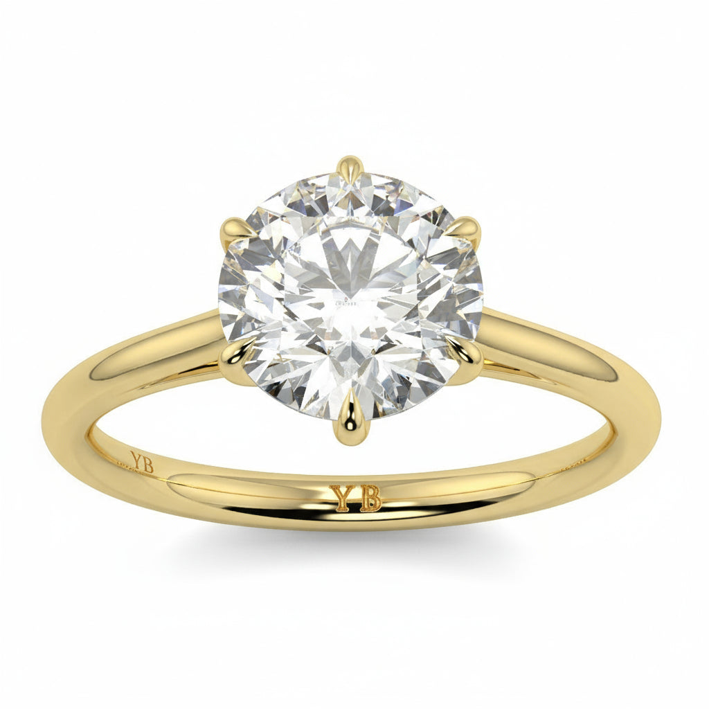 Gold ring with a large diamond and  branding on a white background yb jewellers solitaire engagement ring with 6 claws set similar to tiffany style classic engagement ring round solitare diamond ring yb jewellers trending jeweller and ring designs