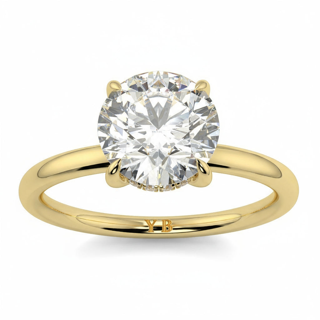 Gold ring with a large diamond on a white background _yb_jewellers_solitaire_engagement_ring_best_selling_design_cushion_shape_diamond_4_claw_with_a_slim_band