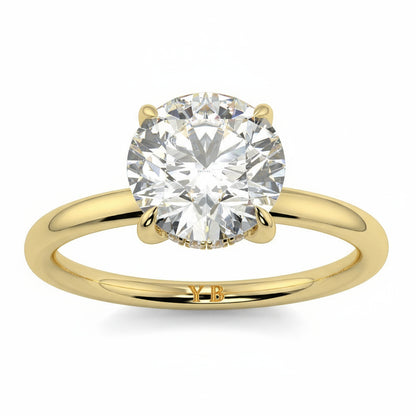 Gold ring with a large diamond on a white background _yb_jewellers_solitaire_engagement_ring_best_selling_design_cushion_shape_diamond_4_claw_with_a_slim_band
