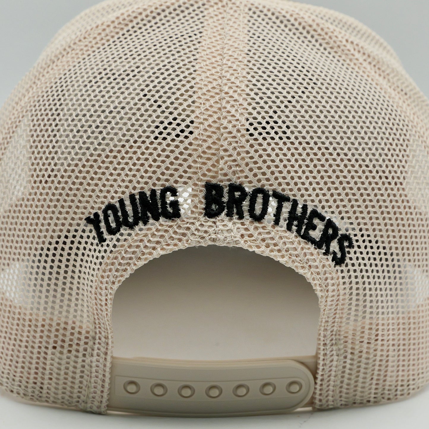 Beige mesh cap with 'YOUNG BROTHERS' text on a light gray background