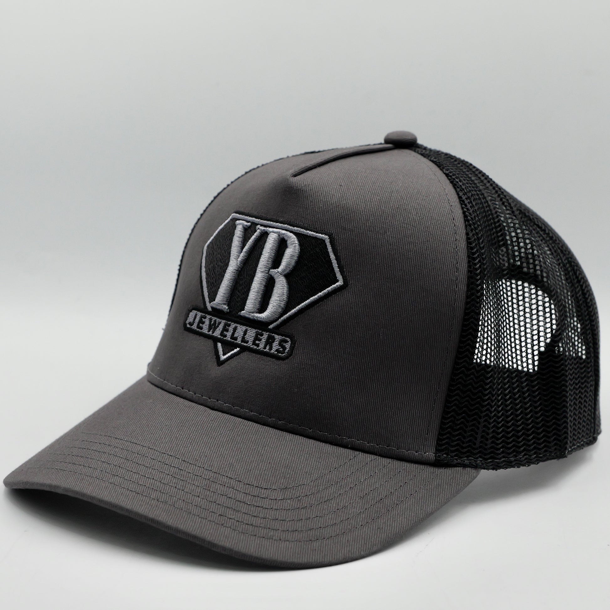 Gray trucker cap with black mesh back and visible branding on a light gray background