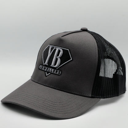 Gray trucker cap with black mesh back and visible branding on a light gray background
