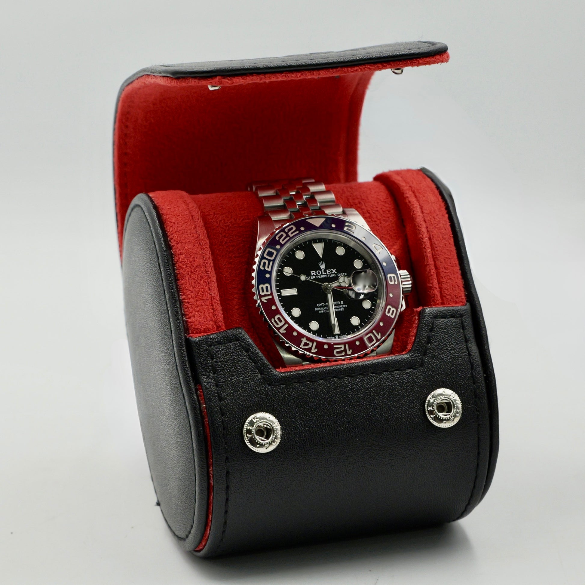 Watch in a black and red display case on a light gray background