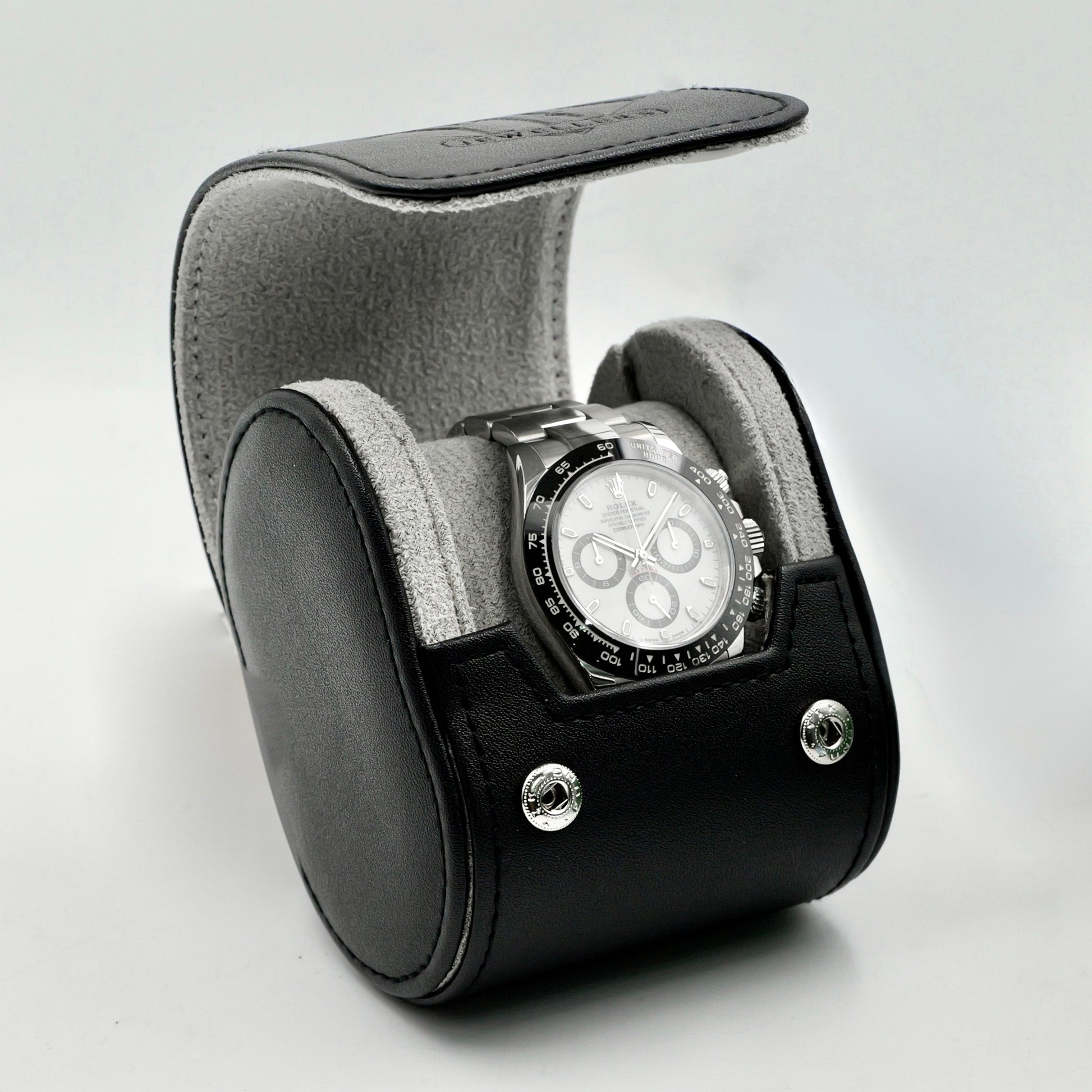 Watch in a black and gray display case on a light gray background
