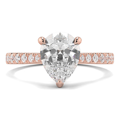 Rose gold ring with a pear-shaped diamond and smaller diamonds on the band against a white background Yb jewellers engagement ring straight band pear diamond