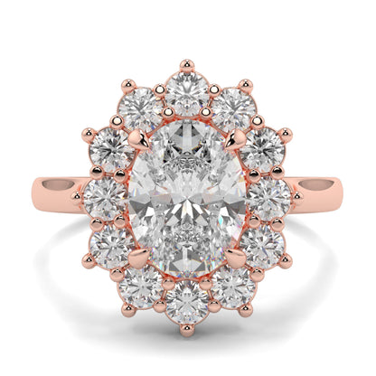 Rose gold ring with a large central diamond and smaller diamonds around on a white background,m Yb jewellers engagement ring with a cluster halo and oval diamond trending design 