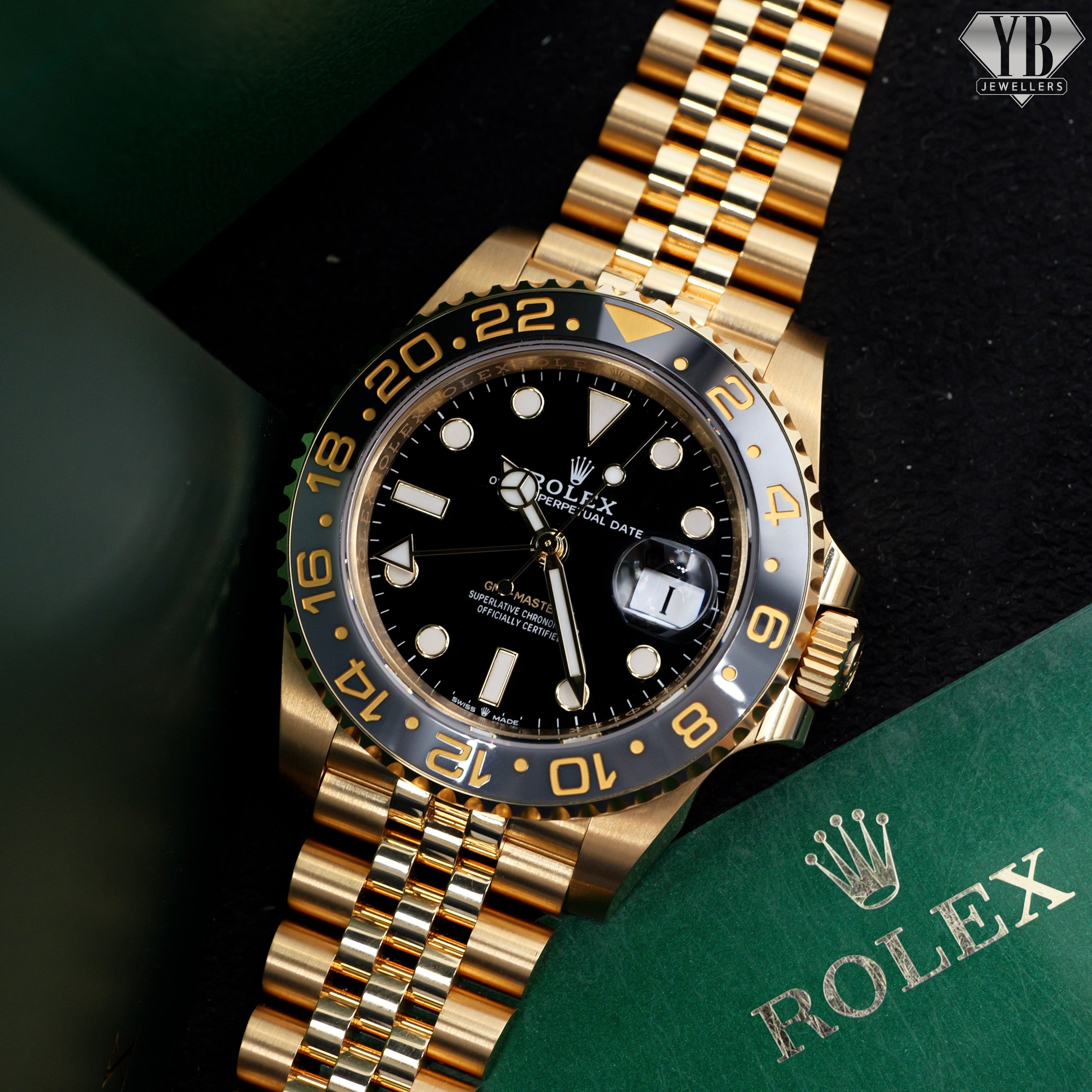 Gold Rolex watch with black dial on a dark background